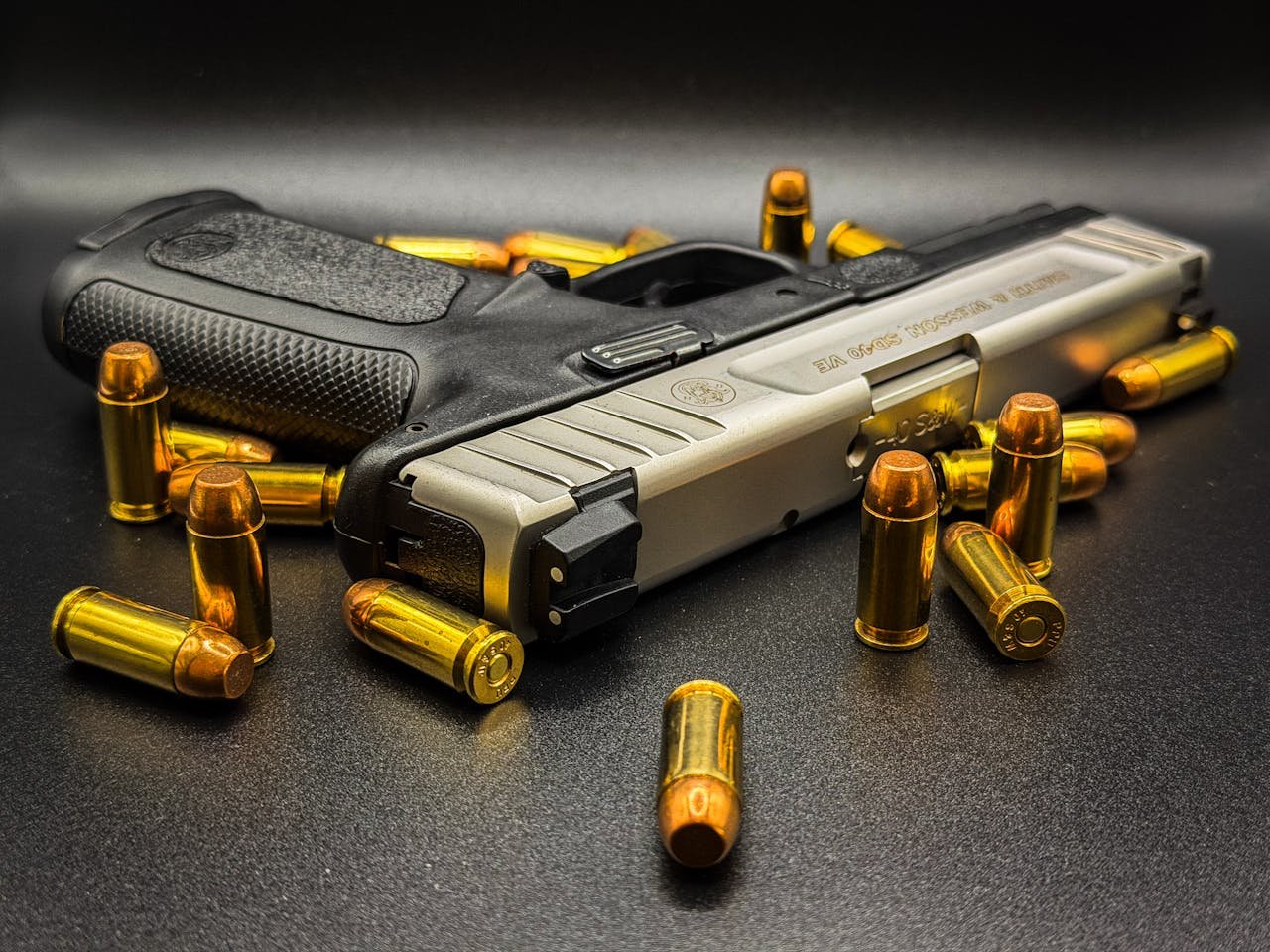 Detailed image of a modern handgun surrounded by bullets, emphasizing weapons and security.